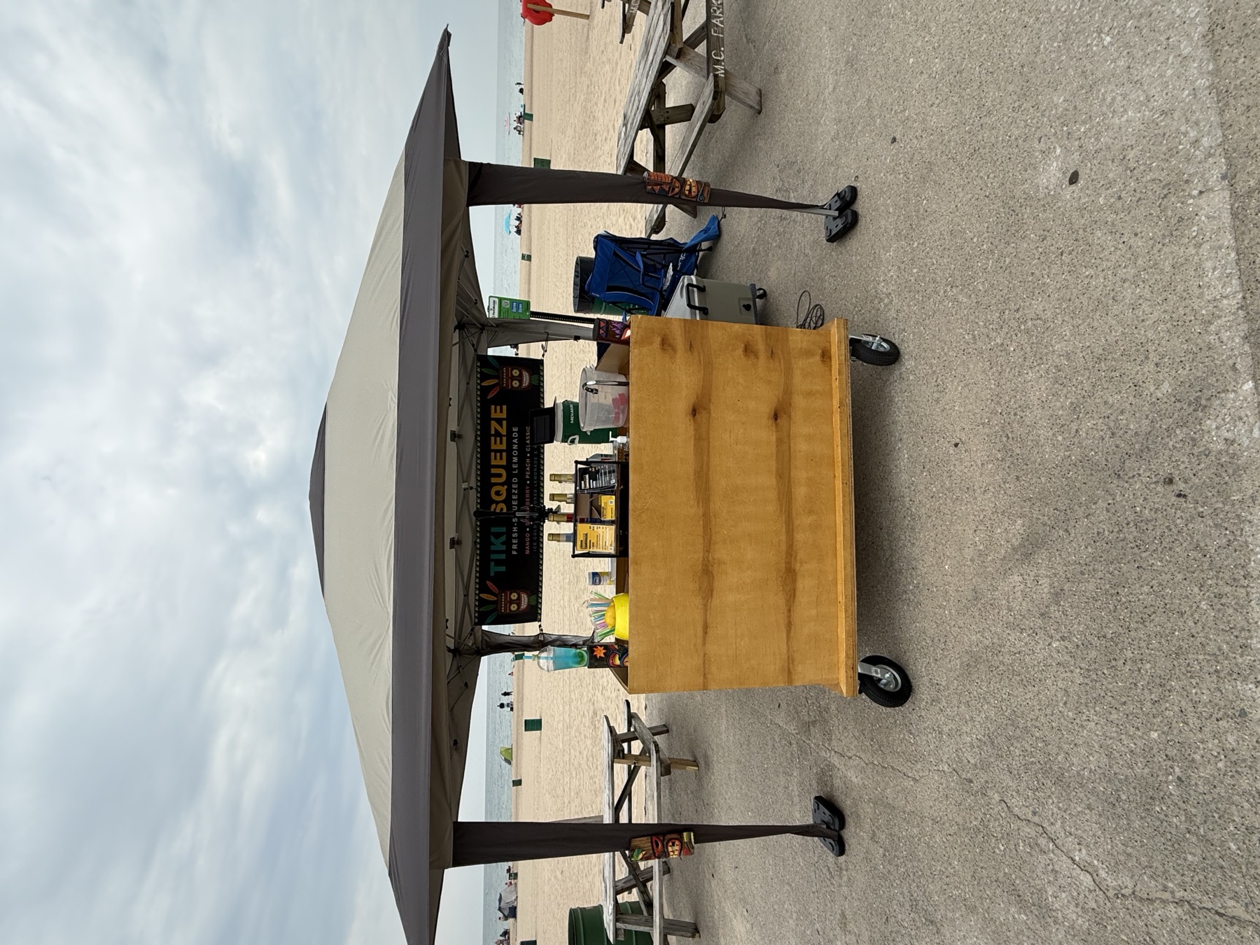 The Tiki Squeeze cart set up under canopy on the lakefront at Washington Park Beach